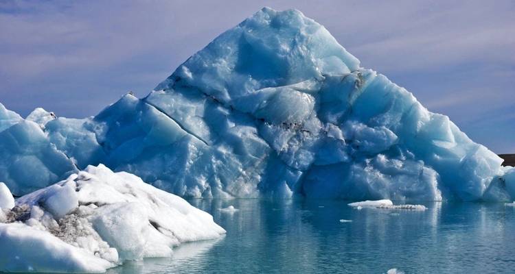 Grote ijsberg drijvend in kalme, ijzige wateren.