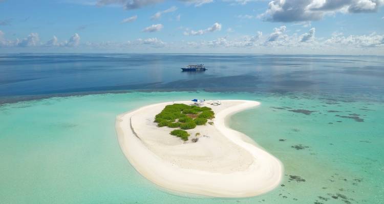Aerial view of a small island with clear blue water surrounding it.