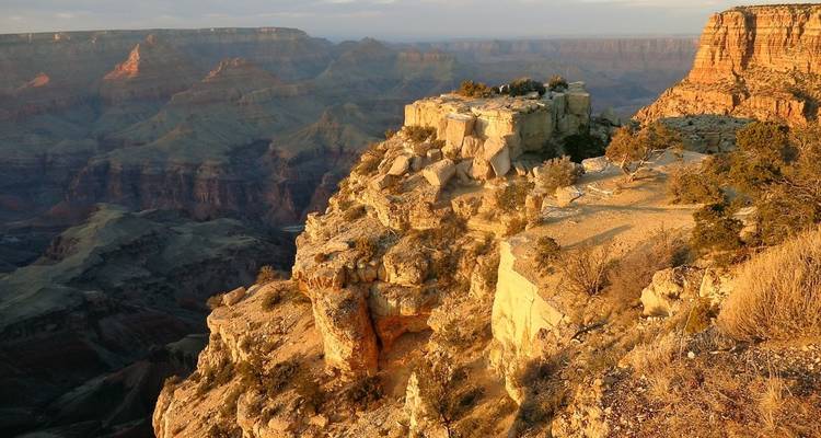 Majestueus uitzicht op de Grand Canyon met zonlicht dat de rotswanden verlicht.