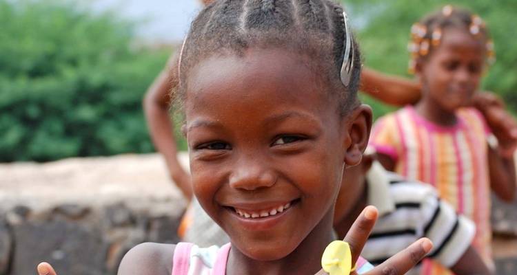 Jeune fille souriante faisant le signe de la paix.