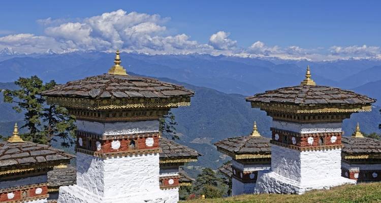 Row of stupas and mountains in the background