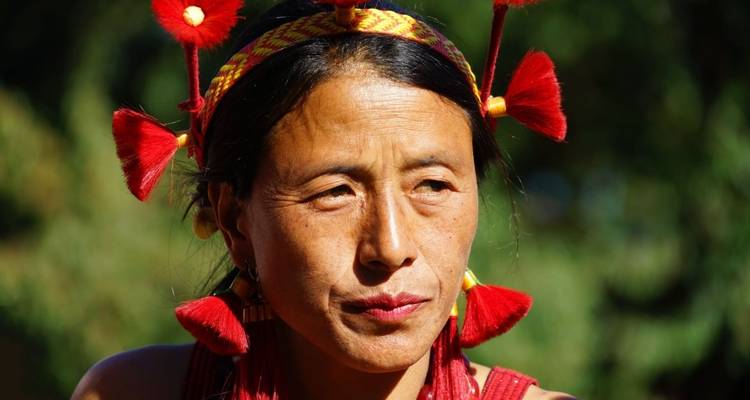 Nahaufnahme-Porträt einer Frau in traditioneller Kleidung mit lebendigen Verzierungen.