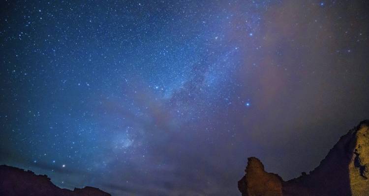 Ciel étoilé au-dessus d'un paysage rocheux.