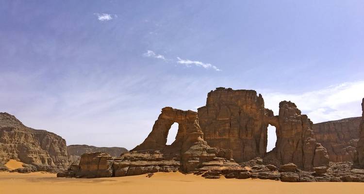 Formations rocheuses dans un paysage désertique sous un ciel bleu dégagé.