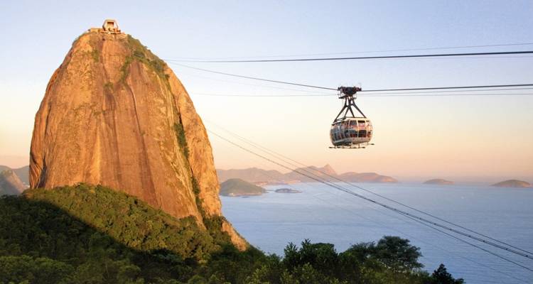 Seilbahn, die zu einem Berg mit Meerblick fährt.