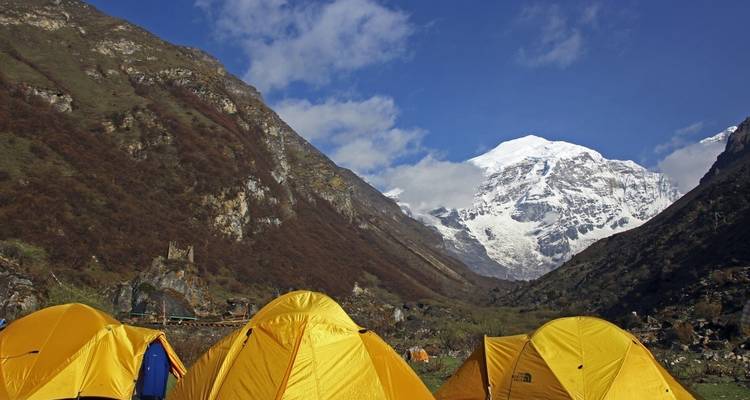A camping site in the mountains with snow-capped peaks.