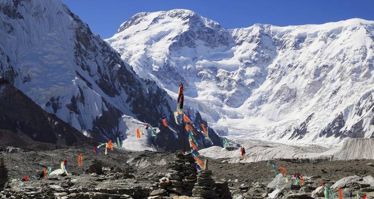 Prayer flags in a mountainous snowy landscape.
