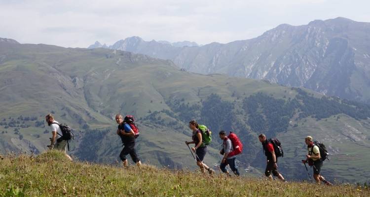 Des randonneurs marchant le long d'un sentier montagneux.