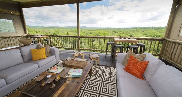 Comfortable open-air lounge overlooking lush greenery.