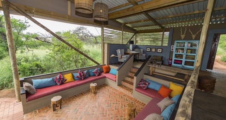 Open-sided seating area with colorful cushions and rustic decor.