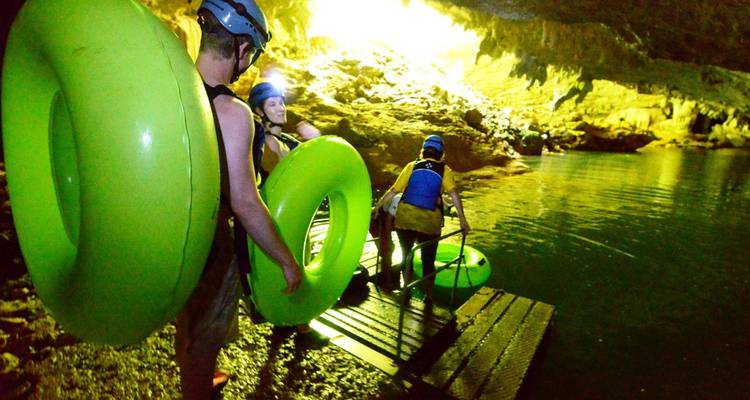 Personas con tubos preparándose para una aventura de tubing en cueva.