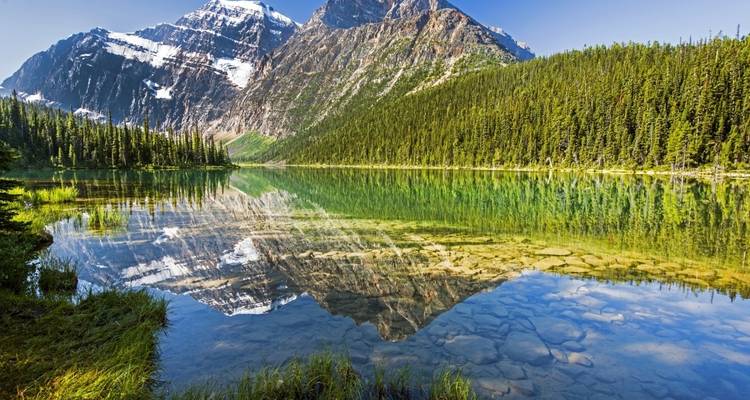 Montagne enneigée se reflétant dans un lac.