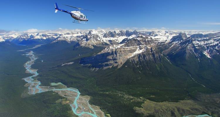 Chaîne de montagnes avec un hélicoptère volant au-dessus.