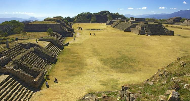 The ancient ruins of Monte Alban with people exploring.