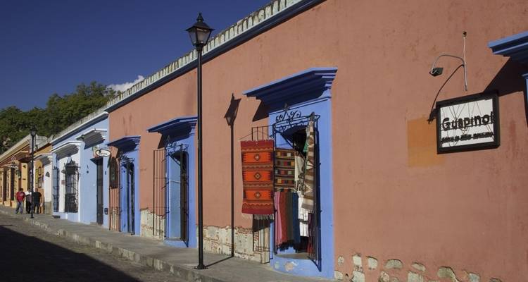 Colorful colonial storefronts with vibrant textiles displayed in Oaxaca.
