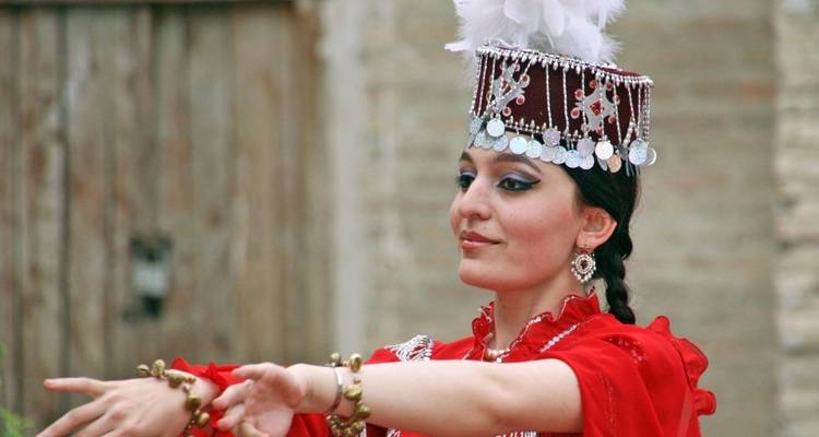 Eine Person in traditioneller Tracht, die einen Tanz aufführt.