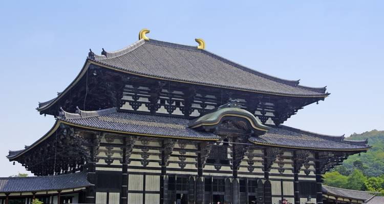 Grand bâtiment de temple japonais traditionnel avec un design en bois complexe.