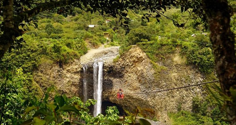 Ein Wasserfall, der in ein üppiges Tal fließt, gesehen von einem hohen Aussichtspunkt.