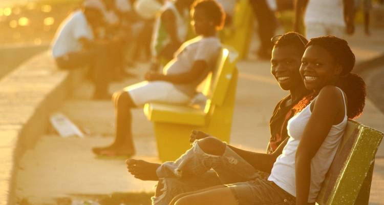 Smiling couple sitting on a bench in warm light.