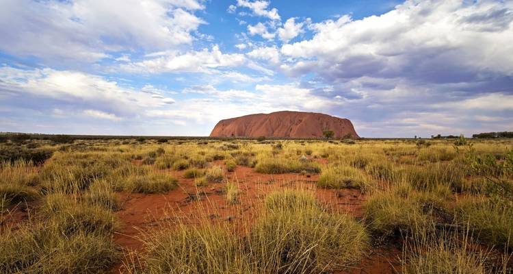 Formation rocheuse d'Uluru dans un paysage désertique.