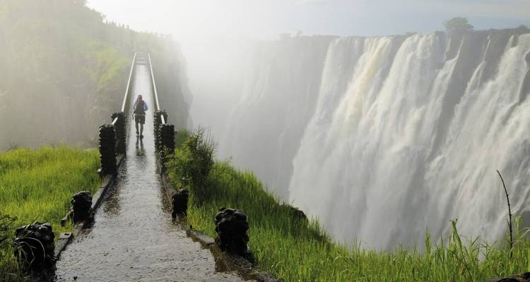 Une personne marchant sur une plateforme à côté des chutes Victoria.