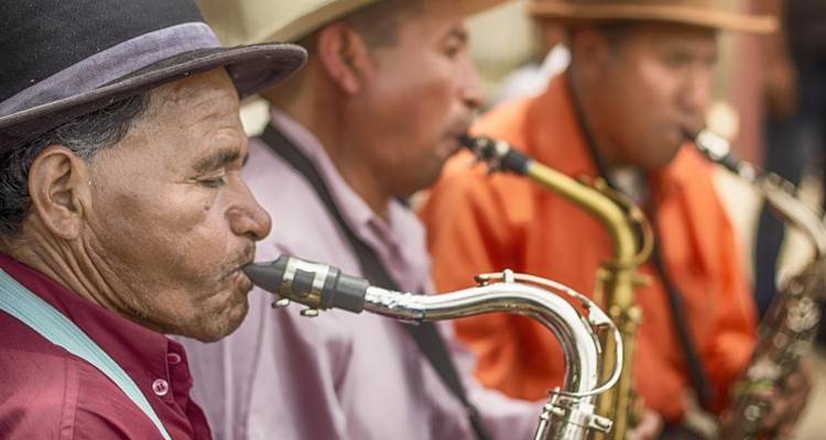 Musiker, die Saxophone im Freien spielen und Hüte tragen.