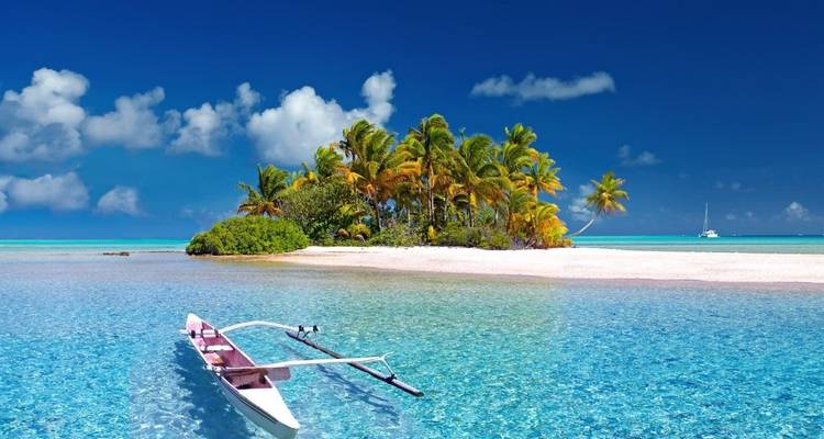 Playa tropical prístina con agua azul cristalina y una canoa.