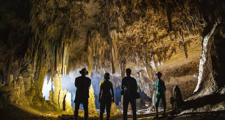Group exploring a cave with impressive stalactites and stalagmites.