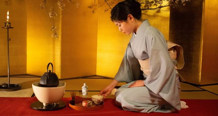 Mujer en kimono realizando la ceremonia del té japonesa