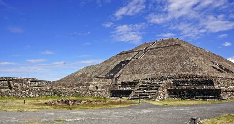A large pyramid structure with steps in an archaeological site.