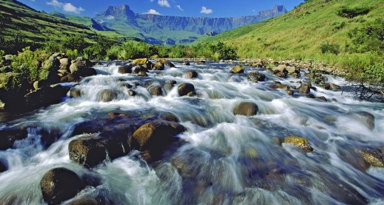 Flowing river with mountains in the background.