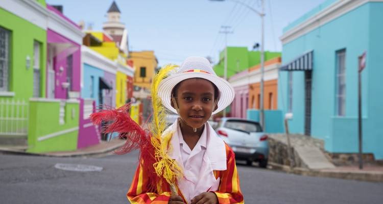 Child wearing colorful clothing in a vibrant street.