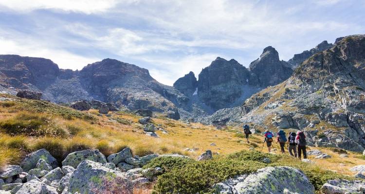 Group of hikers walking towards a mountain range.