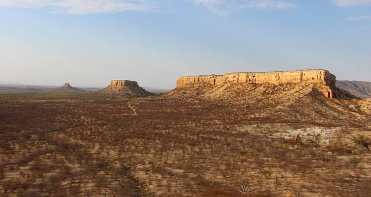 Dry landscape with flat-topped hills in the distance.