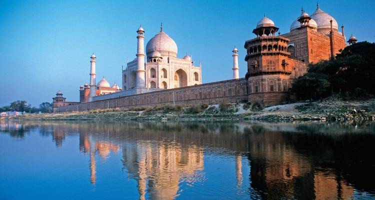 Das Taj Mahal spiegelt sich in einem ruhigen Fluss wider.