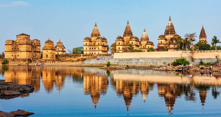 Tempelkomplex mit kunstvollen Schnitzereien, die sich im Wasser spiegeln.