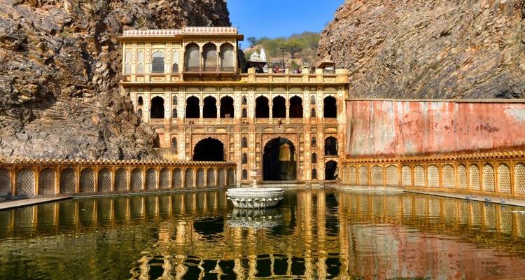Historischer Tempel und Wasserweg, eingebettet in felsige Umgebung.