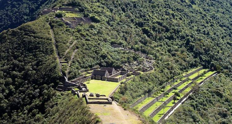 Aerial view of ancient ruins surrounded by lush green forest.