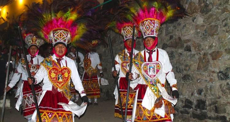 Group of people in traditional colorful costumes during a parade or celebration.