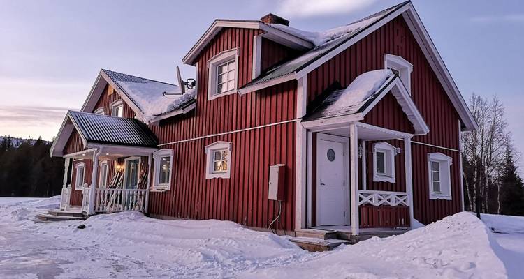 Red wooden house in snowy landscape