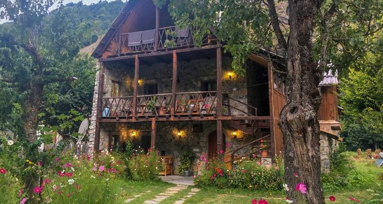 A charming stone cottage with flower garden in a mountainous area.