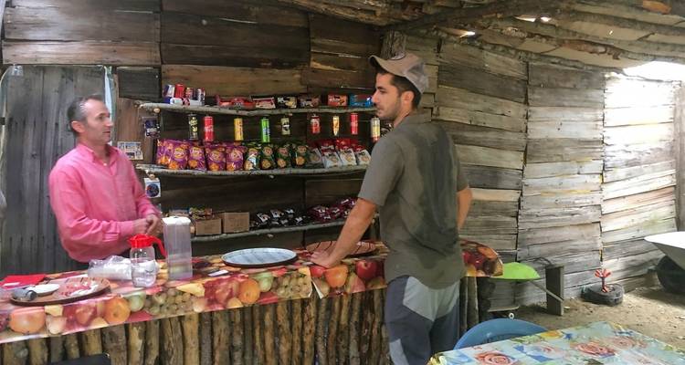 Two men at a rustic wooden store having a conversation.