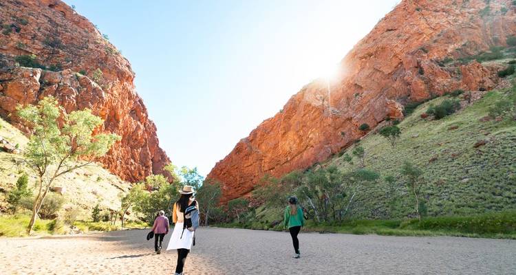Group of people hiking through a canyon.