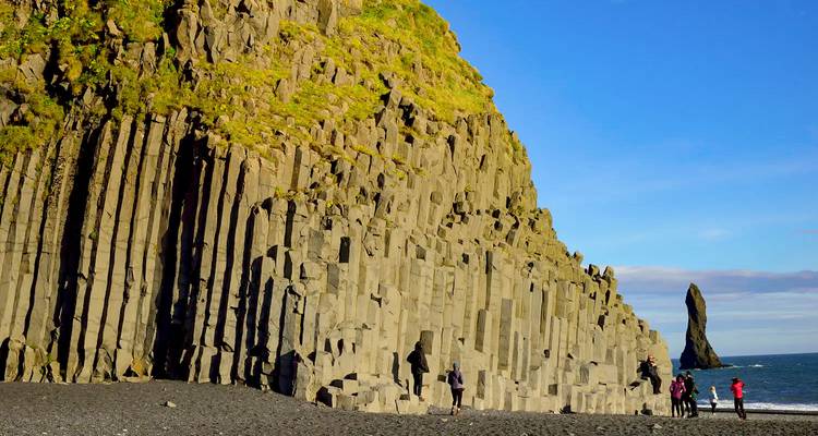 Basalt columns on a beach with tourists