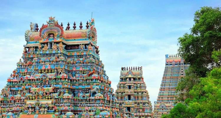 Weite Ansicht eines kunstvoll gestalteten farbenfrohen Tempelkomplexes, umgeben von Grün.