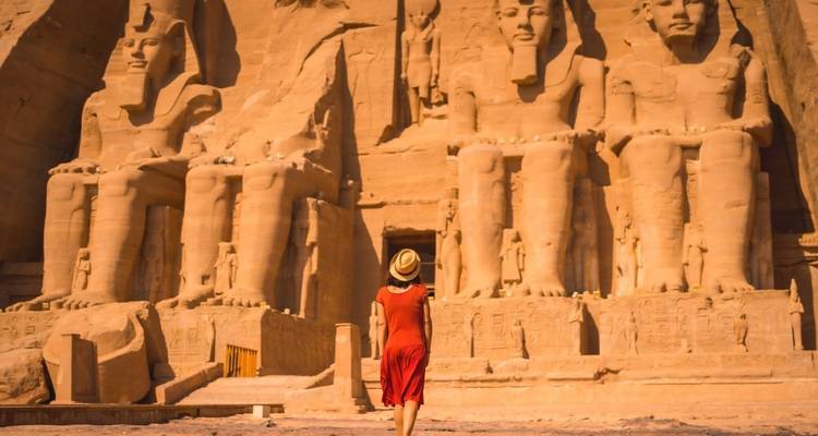 Une personne debout devant les temples d'Abou Simbel.