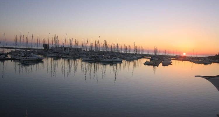 Haven met jachten bij zonsondergang.