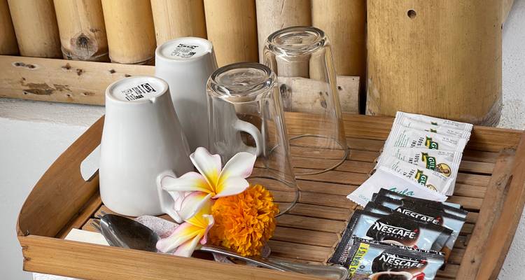 Gastvrijheidsblad met kopjes, glazen en bloemen.