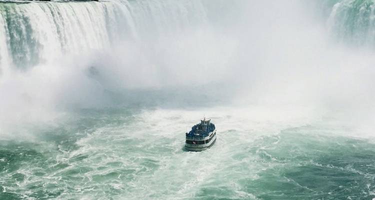 El bote de turismo se acerca a las imponentes Cataratas Herradura rodeadas de niebla y agua rugiente.