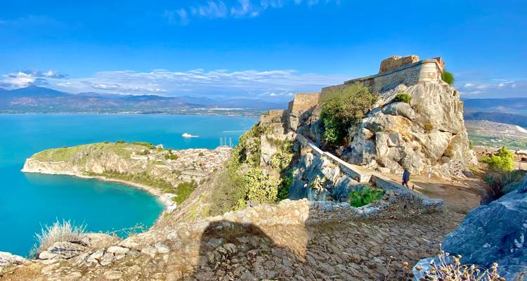 Un point de vue élevé d'une falaise avec une vue sur la mer et les montagnes lointaines.